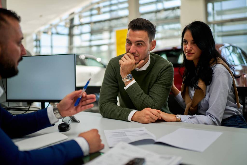 A couple at a car dealership ready to purchase a vehicle.