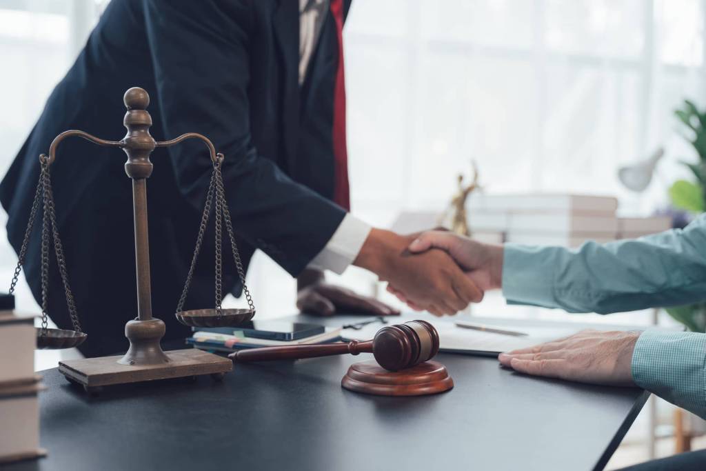 Solicitor and client shaking hands in office.