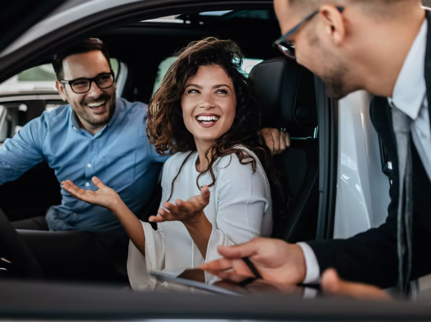 Couple inside a car at a showroom.