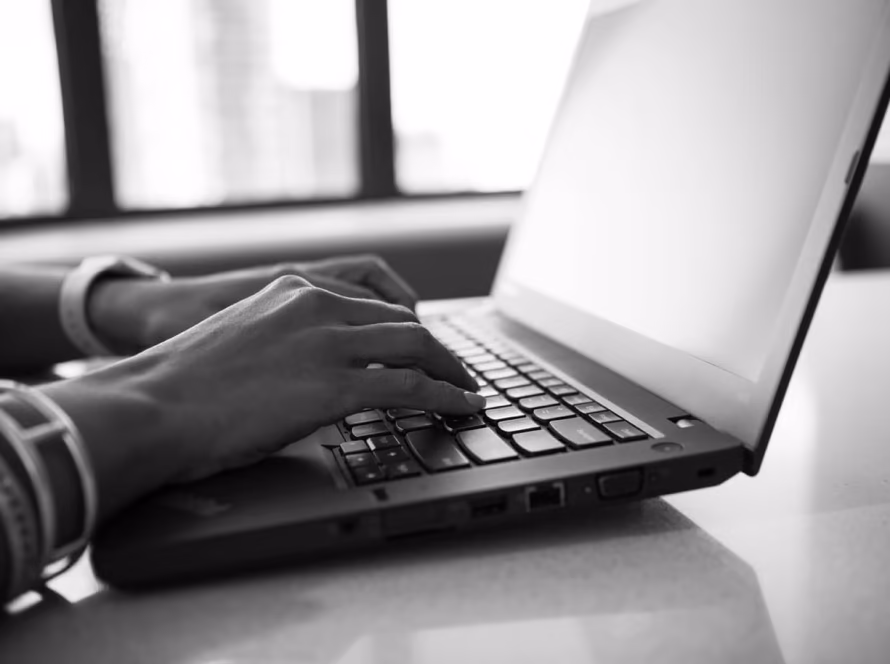 Person typing on a laptop keyboard.