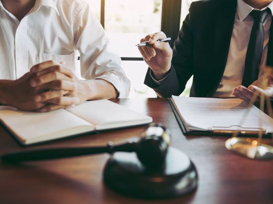 A person sitting next to a solicitor while discussing their case.